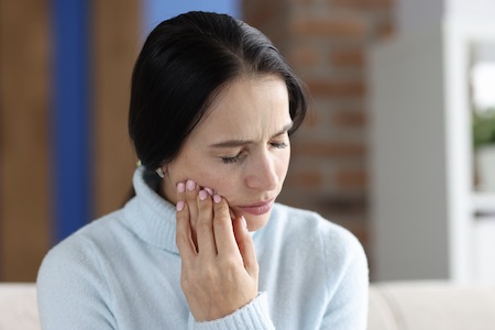 Woman experiencing severe wisdom tooth pain.