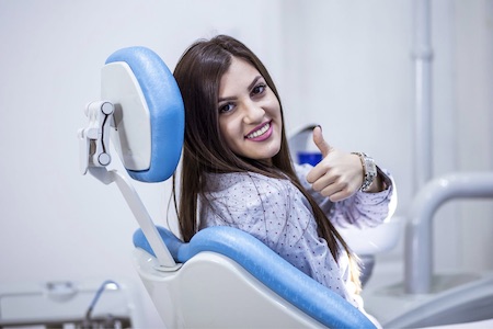 woman in exam chair giving thumbs up