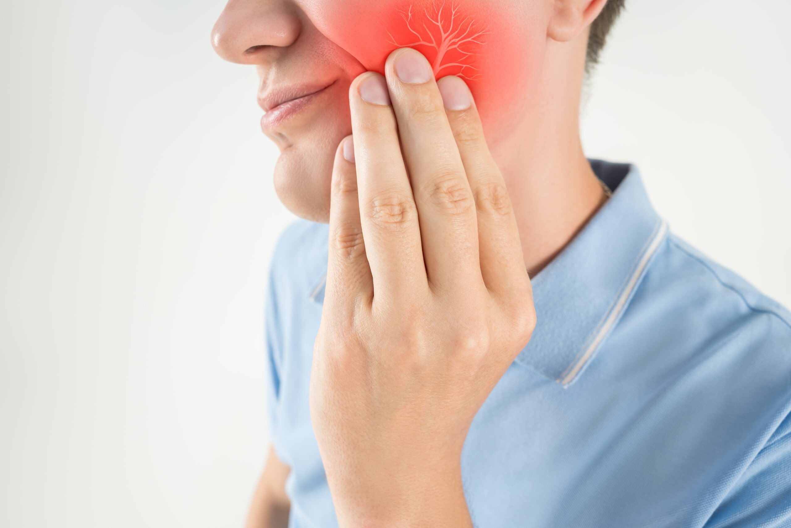 man suffering from wisdom tooth pain