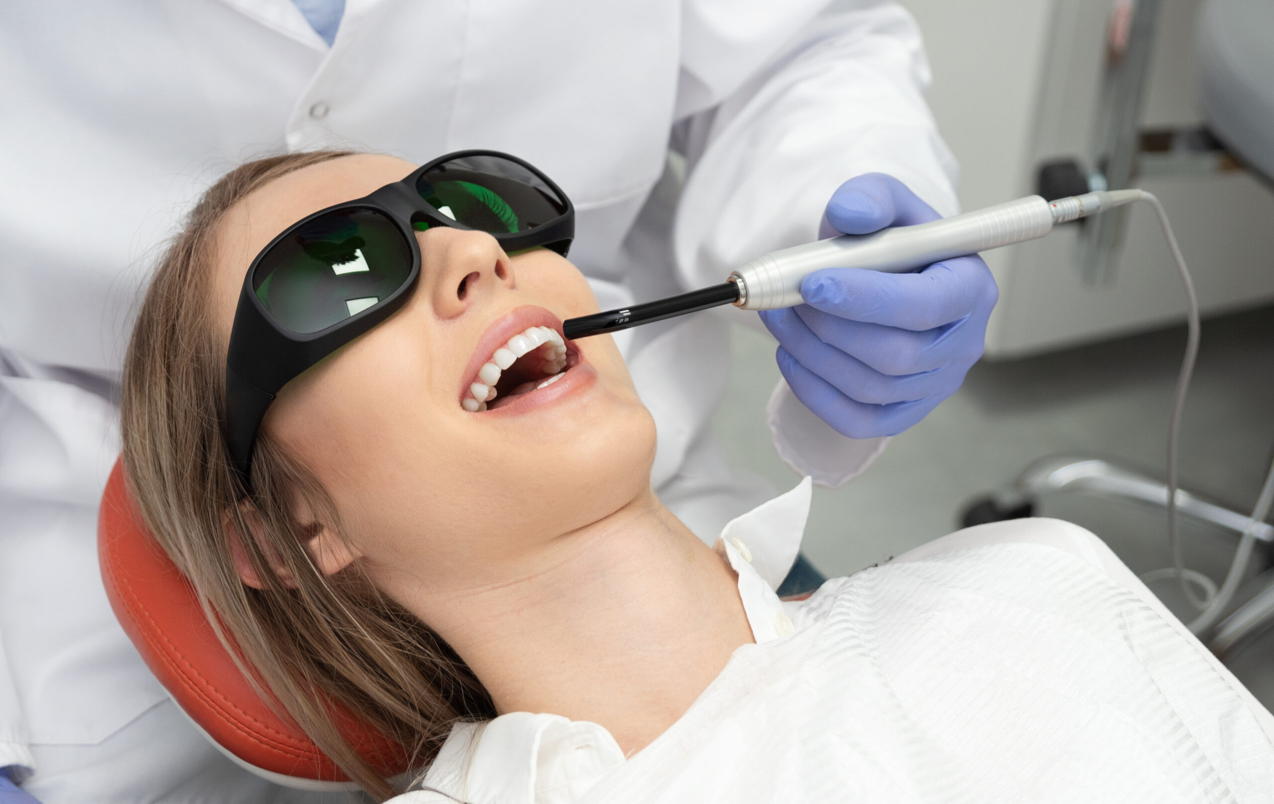 dentist Using a modern method of laser teeth treatment. Dental care, perfect smile