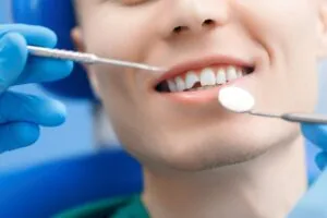 closeup of dentist in blue gloves assessing a chip tooth