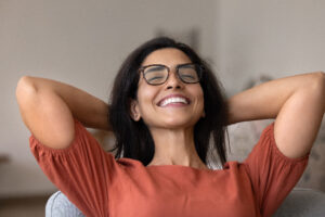 woman relaxing in a dental chair, hands behind head